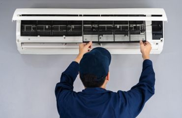 Engineer cleaning and fixing air conditioning unit