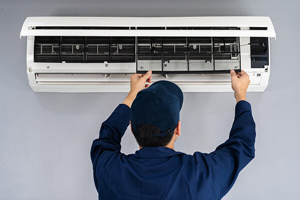 Engineer servicing air conditioning unit